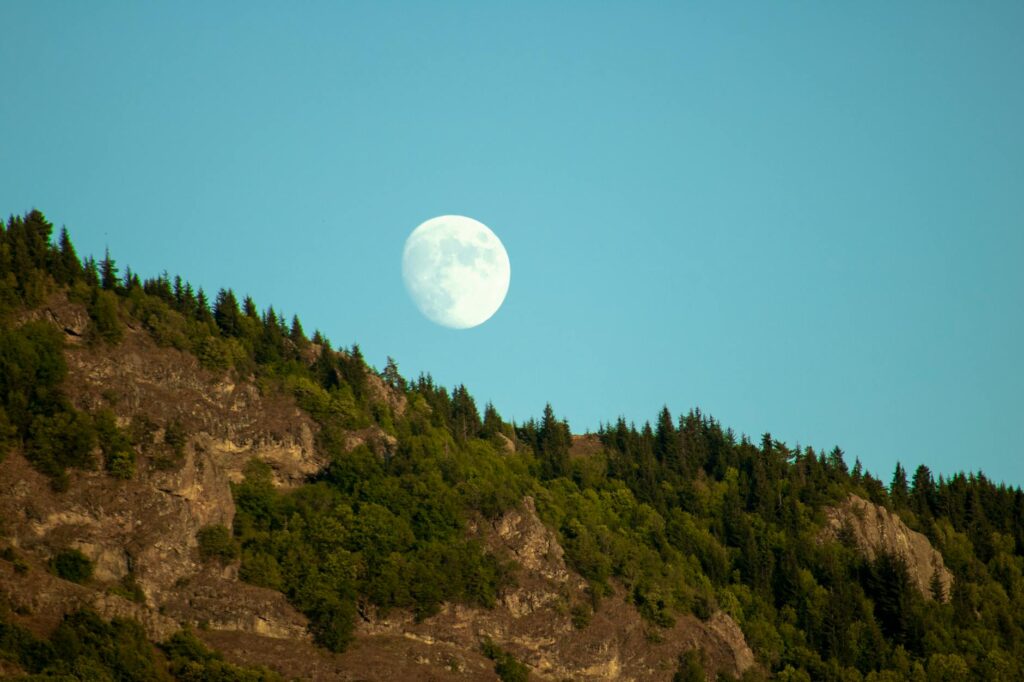 moon on blue sky near mountain